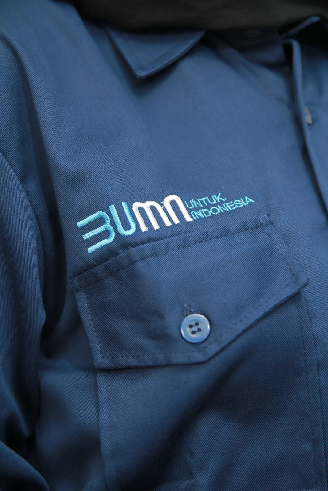 Detail bordir logo di dada seragam kerja